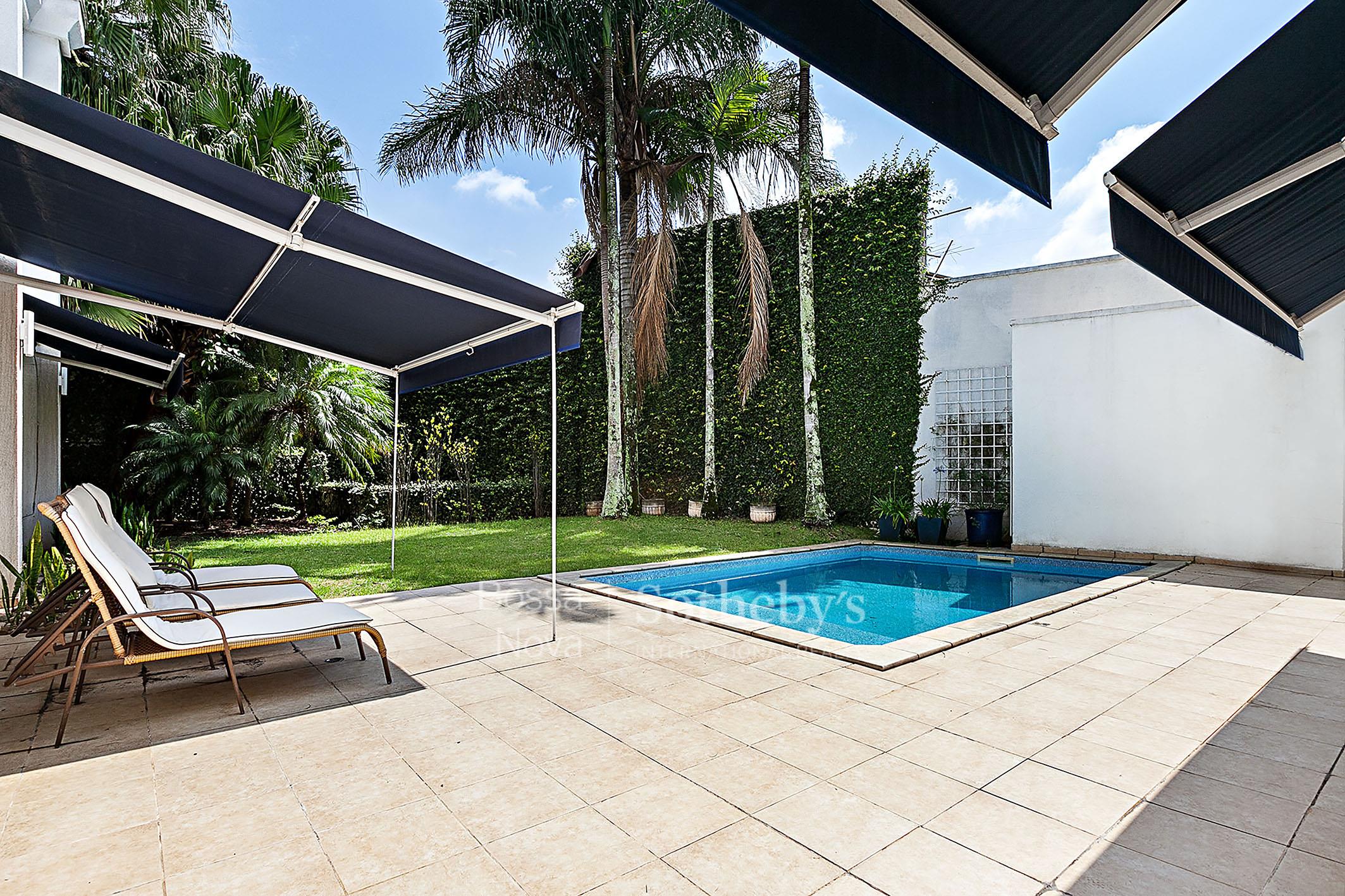 Casa neoclássica com piscina e jardim em rua sem saída